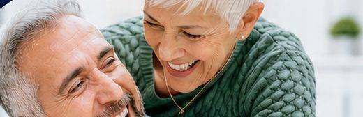 An older couple laughing together at home